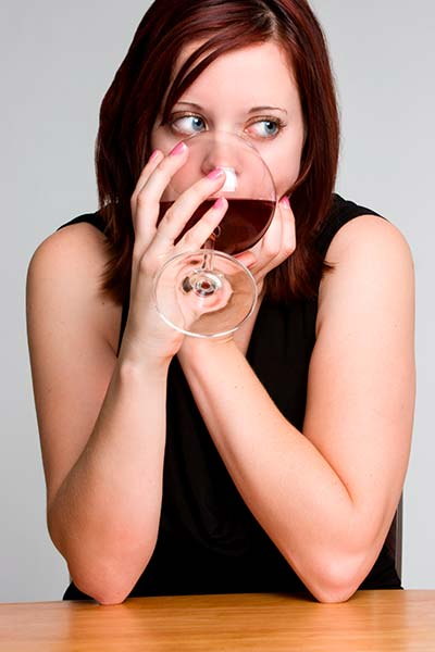 женщина сидит за столом с бокалом вина в руках